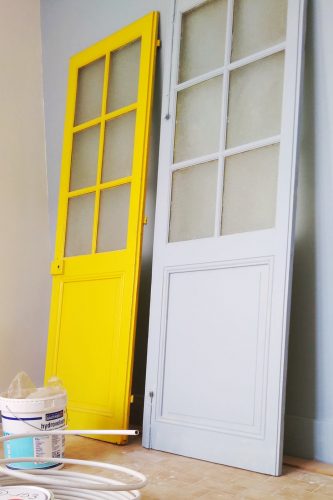 Tarifs & Prestations de décorations d'intérieur : Les travaux d'architecte d'intérieur passent aussi par un coup de pinceau sur les portes. Sur la photo il y a une porte jaune et une porte blanche